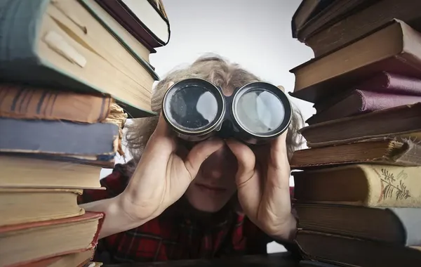 Kostenlos Anonyme Person Mit Fernglas, Die Durch Gestapelte Bücher Schaut Stock-Foto